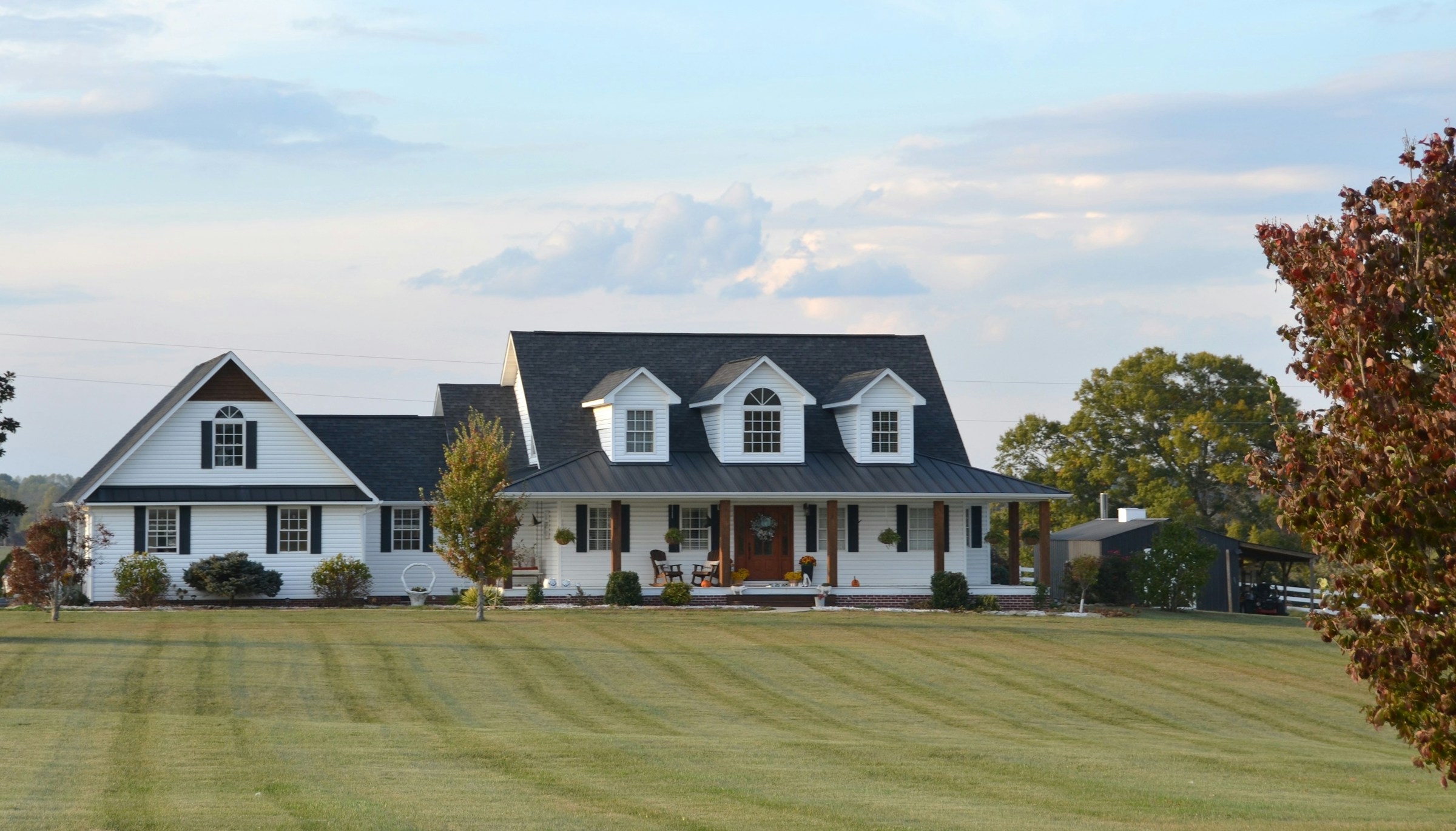 Classic white American farmhouse with a wide porch and lawn